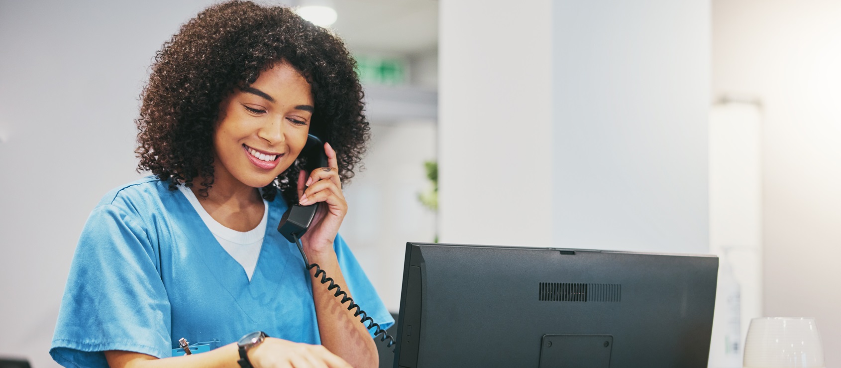 Nurse, phone call and tablet of black woman at hospital with a smile. Clinic doctor, healthcare worker and networking of a young person happy about work conversation and health insurance talk